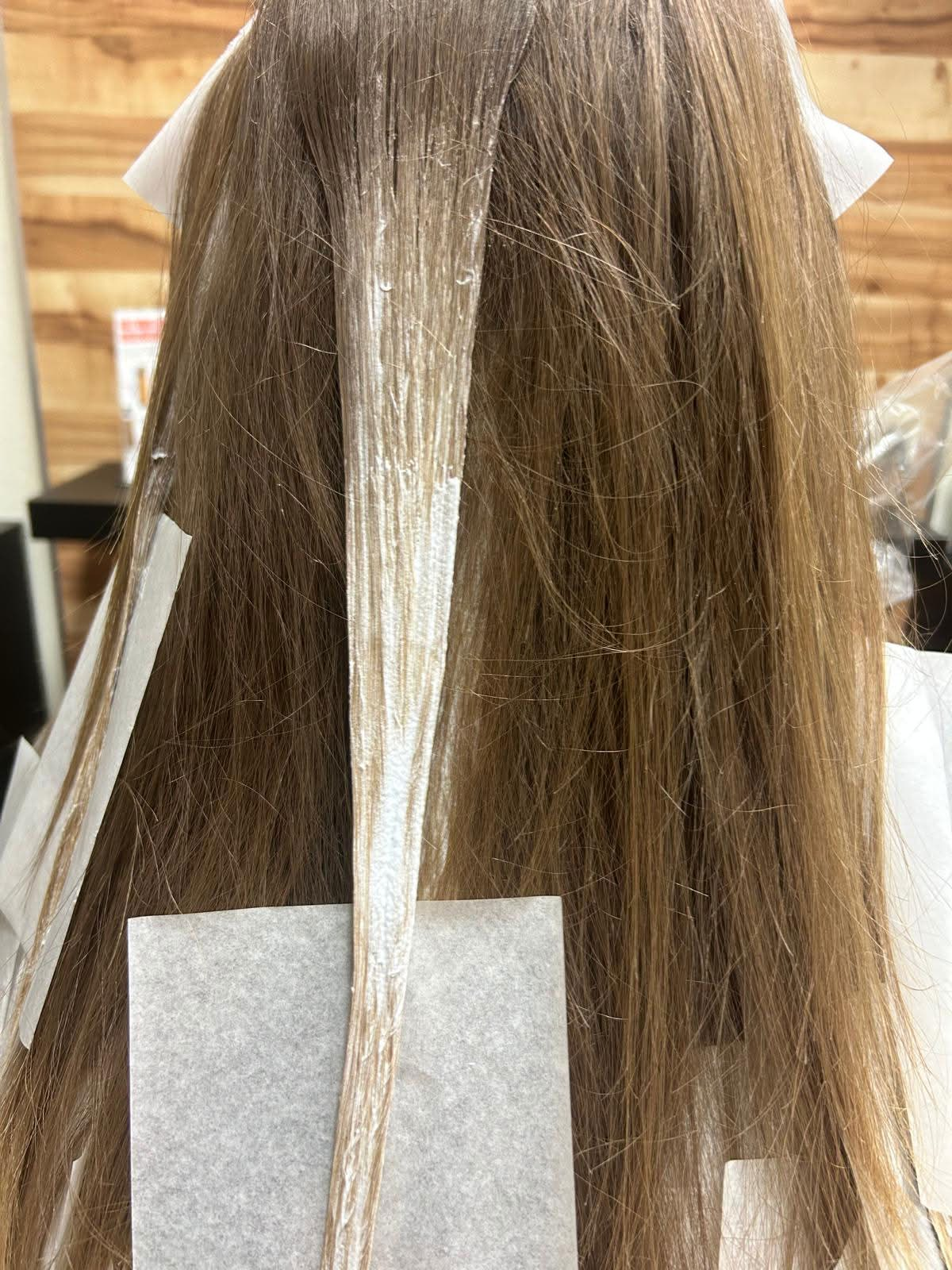 Vorher-Foto: Haarsträhnen während der Blondierung von hinten, kein Gesicht